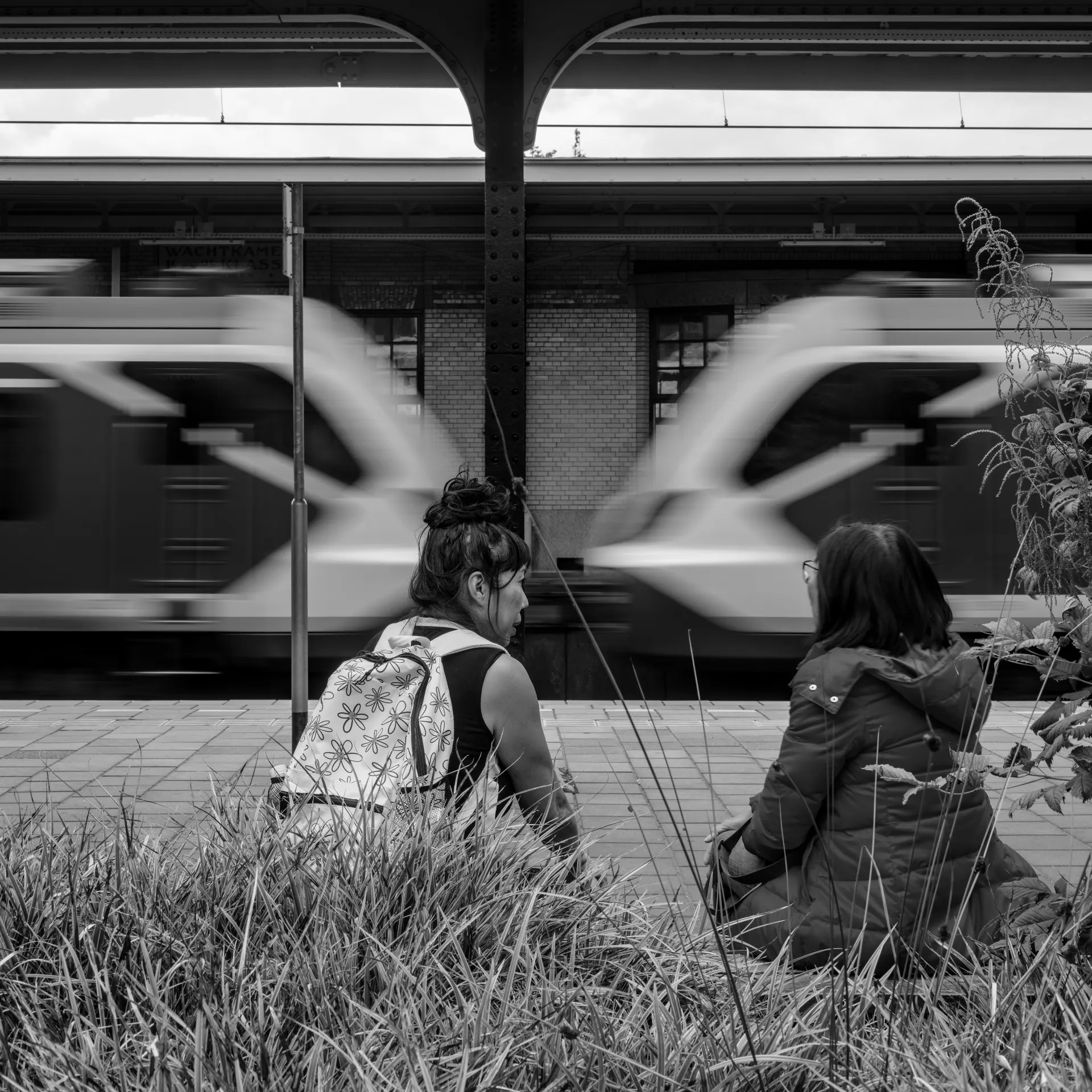 Départ de printemps dans une grande gare parisienne avec lumière douce et voyageurs internationaux