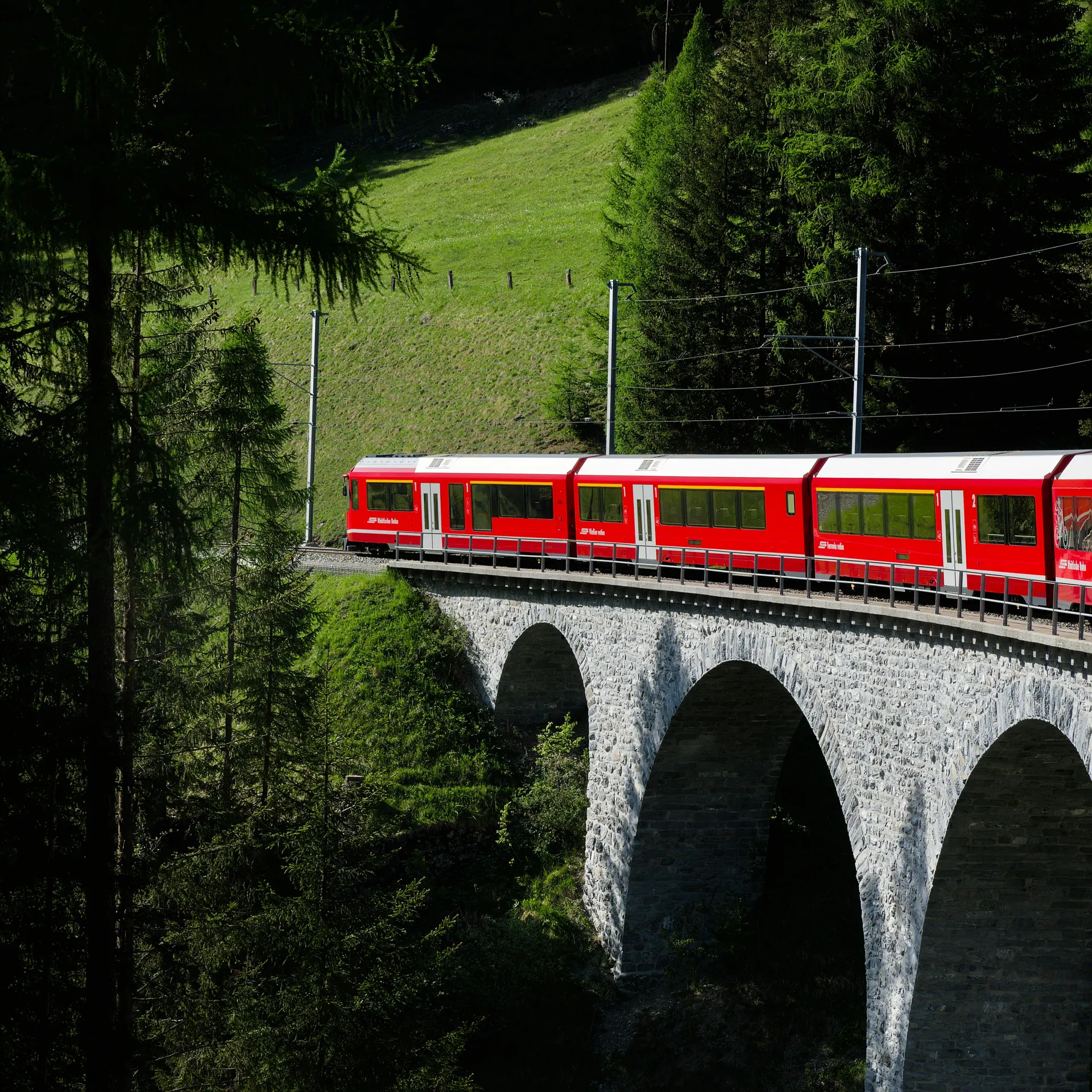 Train suisse longeant un lac alpin avec lumière printanière et paysage clair