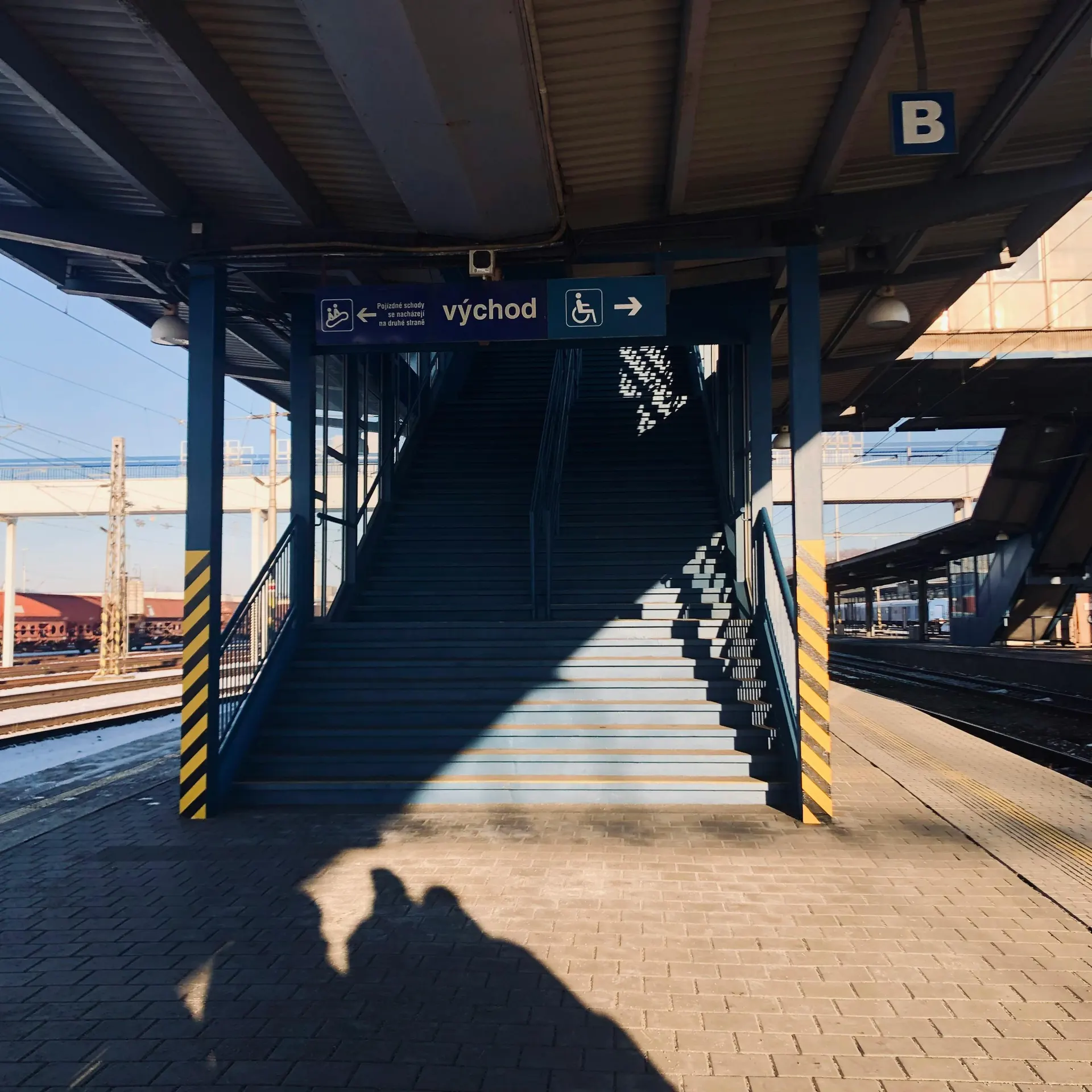 Gare européenne entre Paris et Bruxelles avec signalétique moderne et voyageurs de printemps